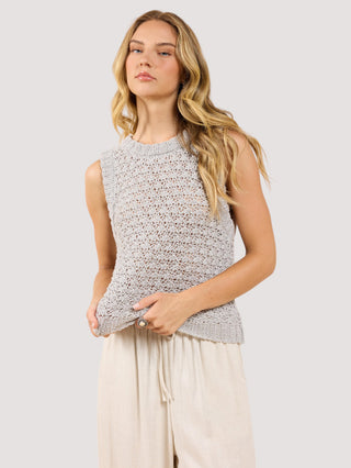 a cozy plush grey sleeveless sweater vest worn with beige pants