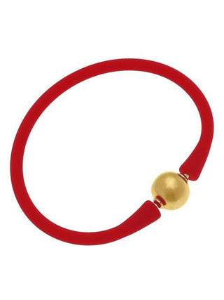 a red silicone stackable bali bracelet with gold plated bead clasp