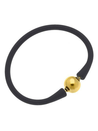a black silicone stackable bali bracelet with gold plated bead clasp