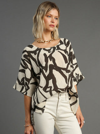 a chic cream top with abstract brushstroke pattern and wide three quarter sleeves
