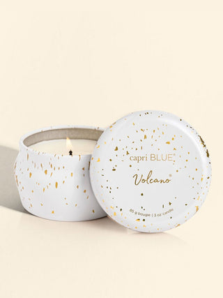 a winter white and gold mini tin holiday candle in the scent volcano