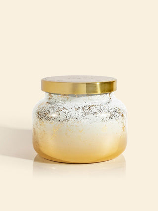 a winter white and golden petit jar holiday candle in the scent volcano