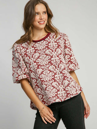 a boxy red knit jacquard top with a round neck and elegant pattern with fun puff sleeves