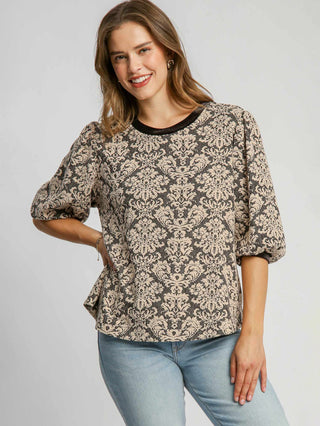 a boxy black knit jacquard top with a round neck and elegant pattern with fun puff sleeves