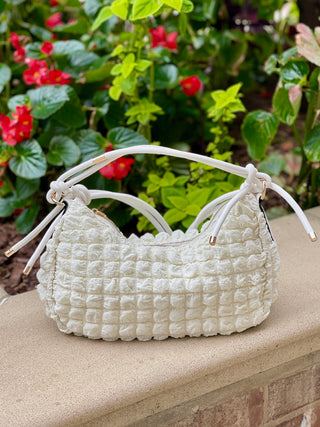 white quilted crossbody purse with knotted strap and metal detail