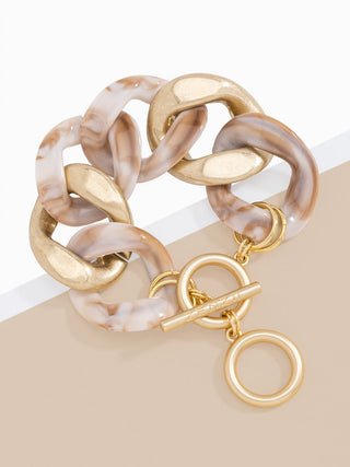 a sophisticated and chunky gold and beige resin curb chain bracelet with toggle closure