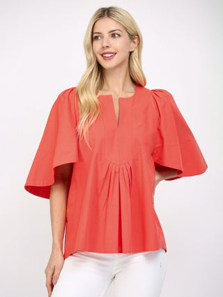 a flattering coral orange cinched blouse with short flutter sleeves