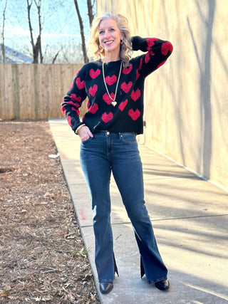 a cozy black sweater with flirty red valentine hearts worn with blue jeans and black boots