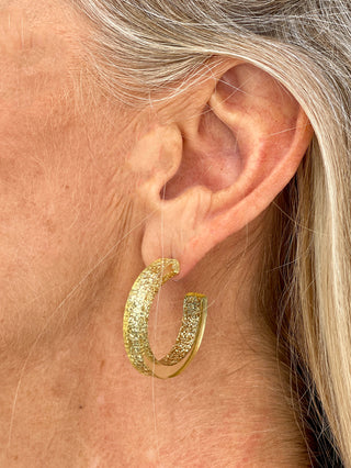 a gold glitter resin open hoop earring