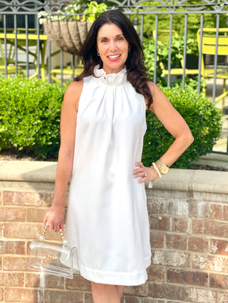 classy high neck white mini dress with ruffled details and a sweet back bow tie