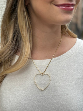 a gold snake chain necklace with an open gold heart and rhinestones