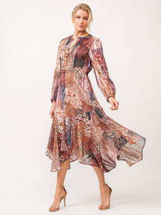 multi colored floral midi dress with v neck and flowy handkerchief hem worn with tan heels 