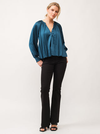 a shimmering and elegant deep teal satin blouse with black pants