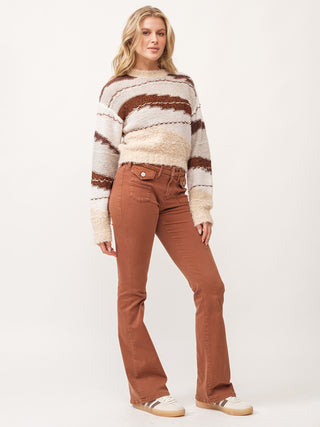 toasted gingerbread brown and cream abstract design long sleeve sweater paired with orange denim jeans