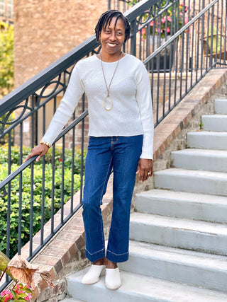 an ivory long sleeve crewneck knit sweater for cozy nights worn with blue jeans