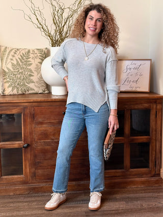 a cozy ribbed knit gray sweater with split sides worn with light denim jeans