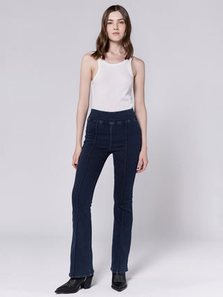 a pair of mid rise dark wash denim jeans with a stretchy waist and flexible fit worn with a white top