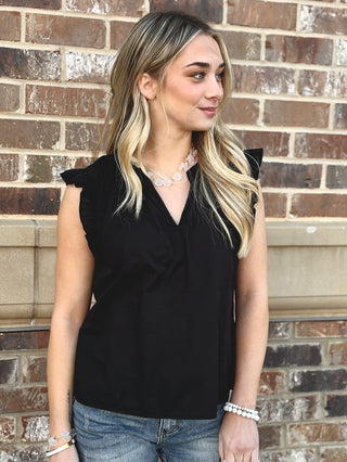 black sleeveless blouse with ruffle details and v neckline