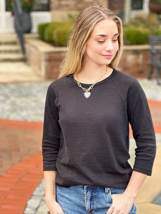 a basic black crew neck shirt with three quarter sleeves