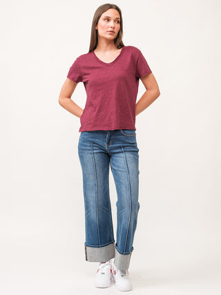 pomegranate short sleeve  v neck slub tee with raw edges worn with baggy denim jeans