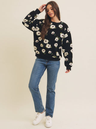 black fluffy long sleeve pullover textured with white floral design worn with blue denim jeans