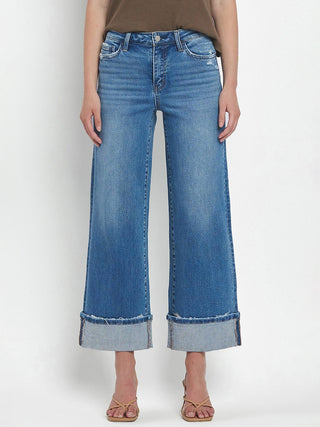 a pair of medium wash denim jeans with wide leg cuff