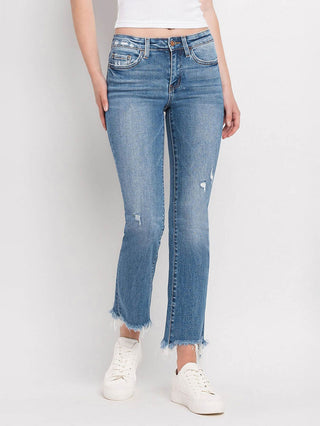 a pair of medium wash denim jeans with bootcut and distressed hem 