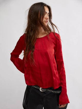 red long sleeve blouse with a scoop neck and open back with tie closures