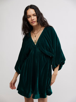 a shimmering emerald green velvet mini dress with a v neck and relaxed fit