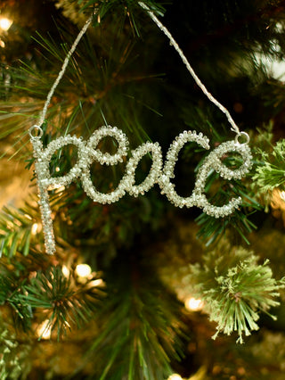 decorate your christmas tree with a cursive beaded word ornament in green that reads peace for holiday home decor