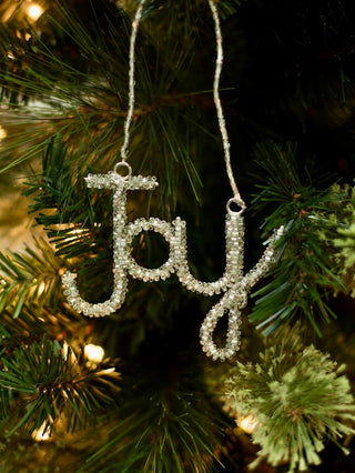 decorate your christmas tree with a cursive beaded word ornament in green that reads joy for holiday home decor