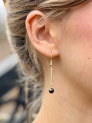 sleek gold bar dangle earrings with a shimmering black hematite bead