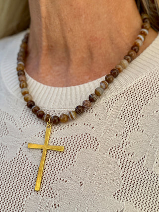 a brown gemstone beaded necklace with a gold cross pendant