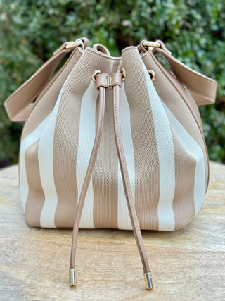 a tan striped bucket bag with a drawstring closure zip pocket and spacious interior 