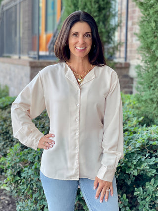 a soft flowy cream button up blouse with a belt tie at the back