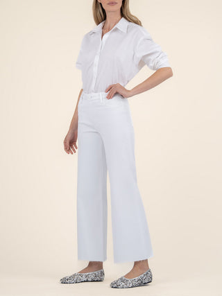 a soft pair of optic white high rise wide leg denim jeans worn with a white blouse