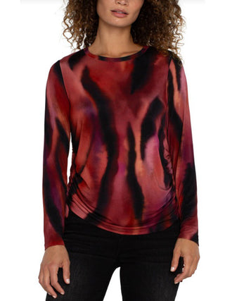 soft knit crew neck top with side ruching and a fiery abstract pattern in red, orange, and black