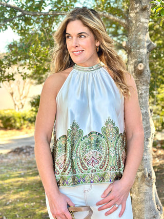 a silky cream halter top with a vibrant olive paisley pattern