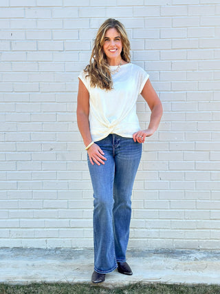 a soft lightweight short sleeve white top with a flirty front twist detail worn with blue jeans