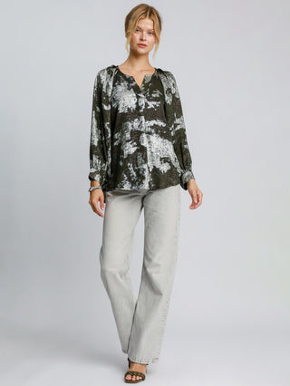 a soft elegant olive metallic v neck blouse with a night time abstract print worn with washed jeans