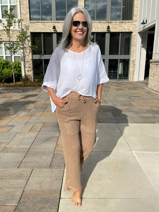 coastal boho netted pants in a tan color with elastic drawstring worn with a white top