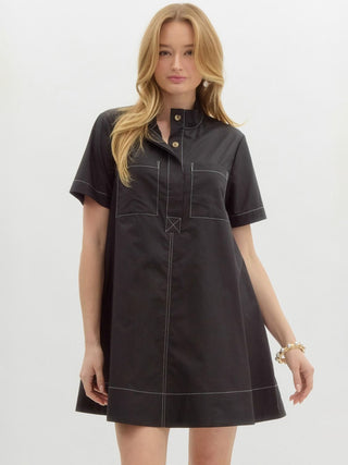 a mini black dress with a high neck button up placket and white stitching 