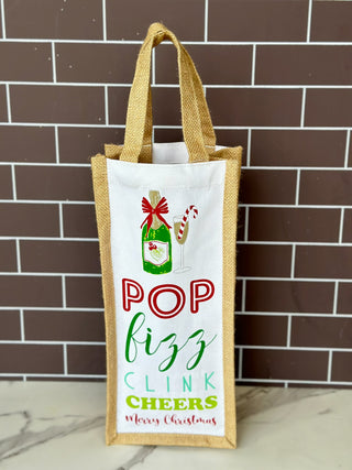 a fun holiday wine gift bag that says pop fizz clink and cheers