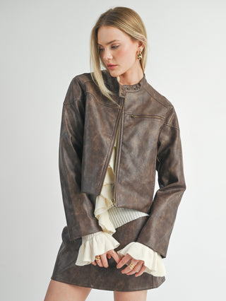 a chocolate brown leather biker jacket with a zipper front and pockets worn with a leather skirt