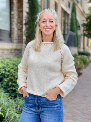 a long sleeve crewneck ivory sweater with delicate stitch details