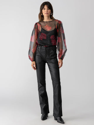 a fun sheer black and red rose long sleeve blouse for a night out worn with black pants