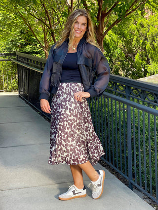 a flowy pleated midi skirt with a chocolate spot design paired with a black top