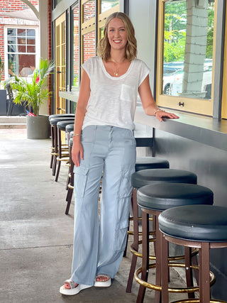 essential white cotton slub knit twist tee top with front pocket and short sleeves worn with blue gray cargo pants