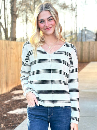 a casual light oak cream and black striped v neck sweater top