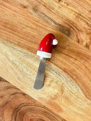 a silver cheese spreader with a fun festive santa hat handle